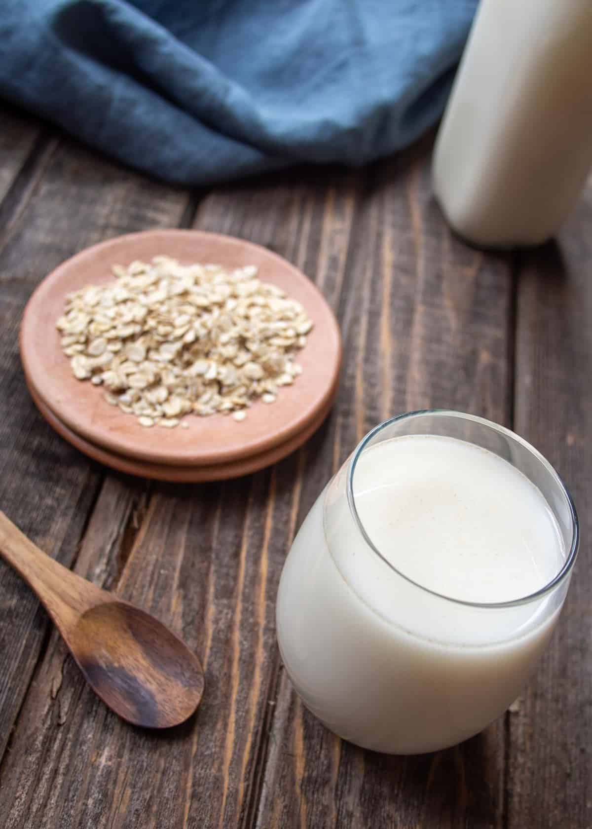Homemade Oat Milk In Glass with Oats On Side