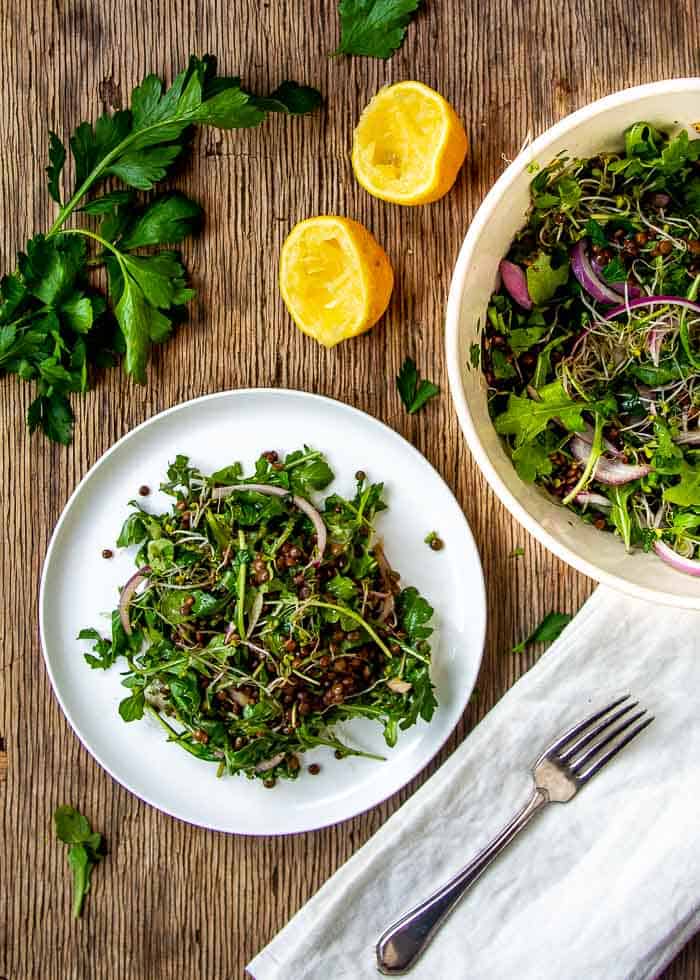 Lentil Salad on White Plate with Lemons and Parsley