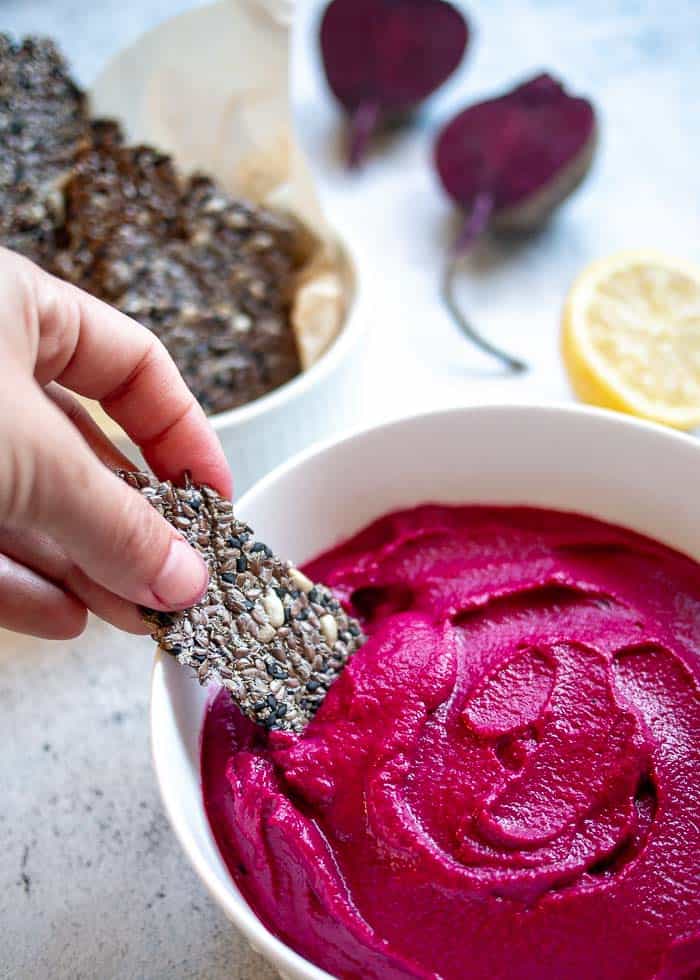Seed Cracker Dipped Into Beetroot Dip