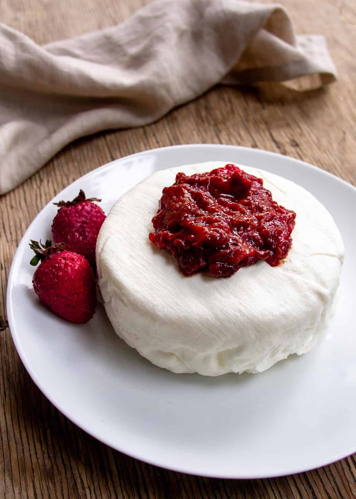 Labneh on white plate topped with berries