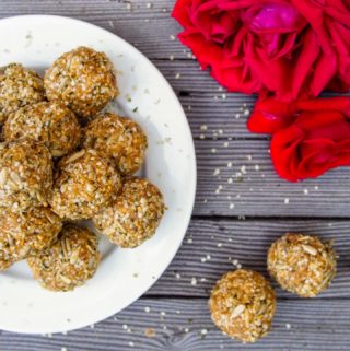 close up of high protein balls on white plate with red rose