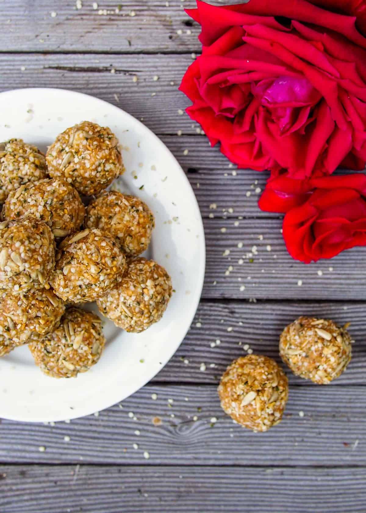 close up of high protein balls on white plate with red rose