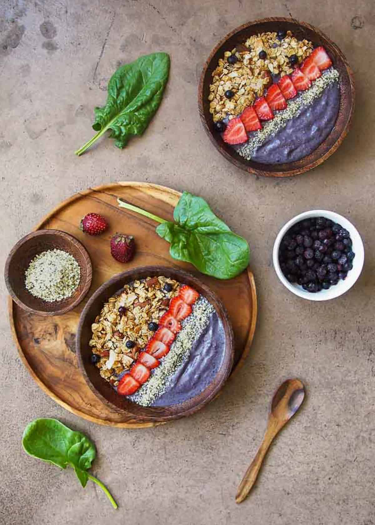 Purple Smoothie Bowls with spinach and berries and hemp on the side