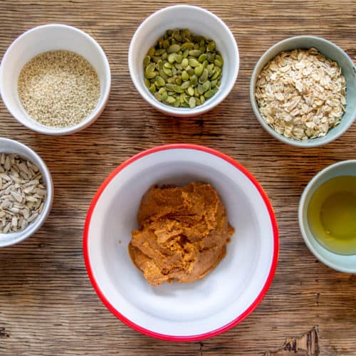 Ingredients for seedy peanut butter oatmeal cookies in white bowls