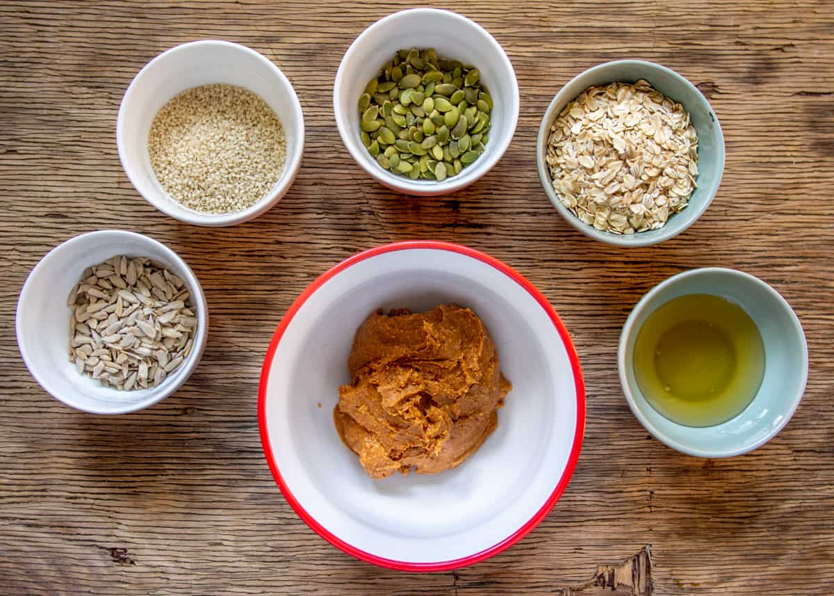 Ingredients for seedy peanut butter oatmeal cookies in white bowls