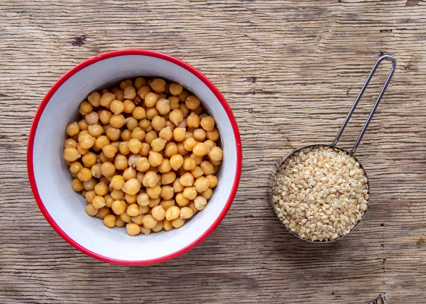 canned chickpeas in a bowl, and dry brown rice measured out