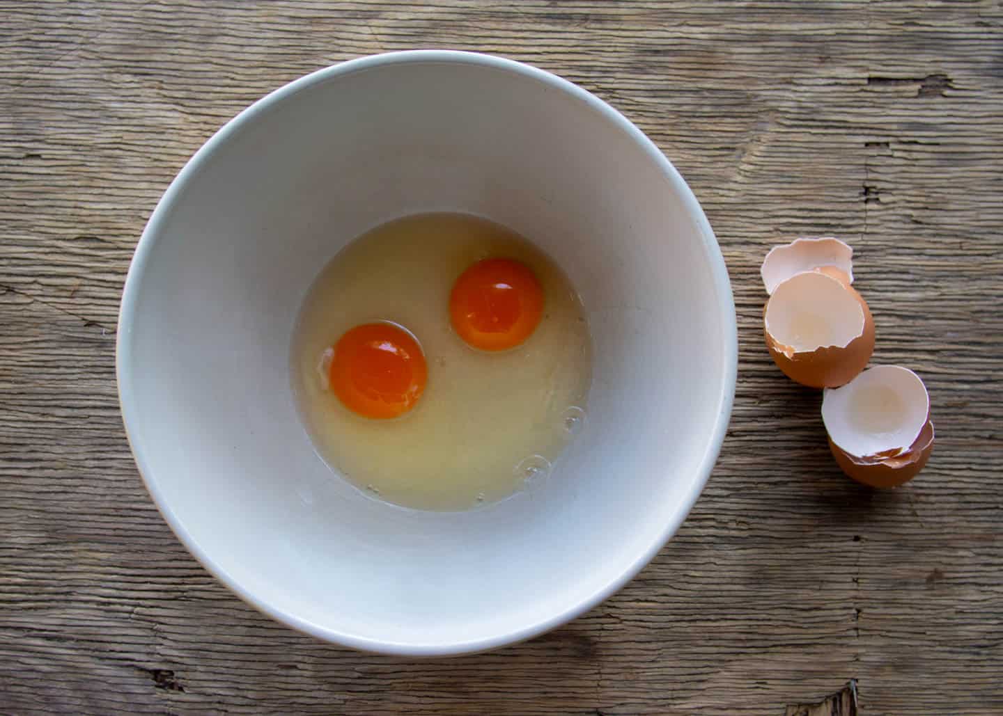 2 cracked eggs in white bowl